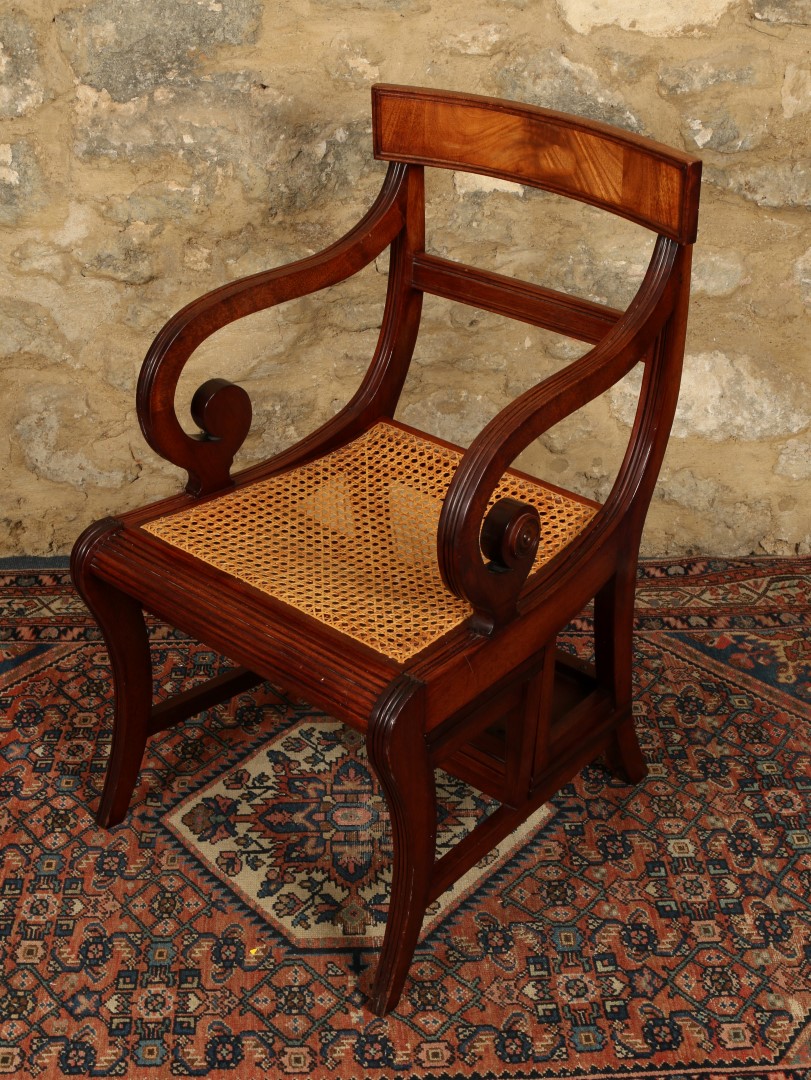 A REGENCY STYLE MAHOGANY METAMORPHIC LIBRARY CHAIR with scroll arms, caned seat folding to a four