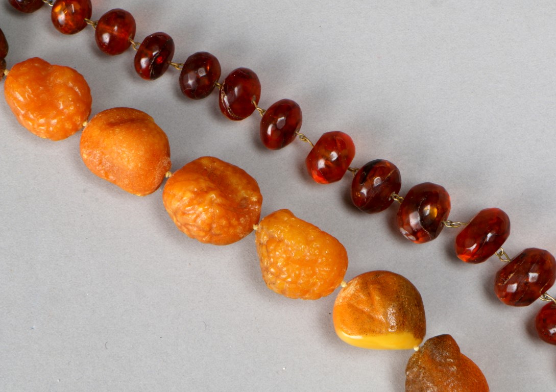 A GRADUATED BUTTERSCOTCH BEAD NECKLACE of natural form, 21" long, 103 grams in weight; and a