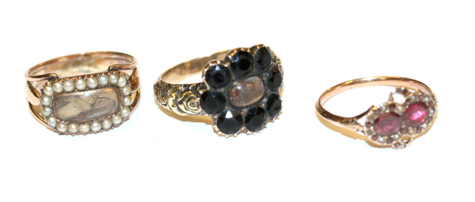 A VICTORIAN PEARL SET MOURNING RING set with hair; an early garnet and pearl set ring; and a further