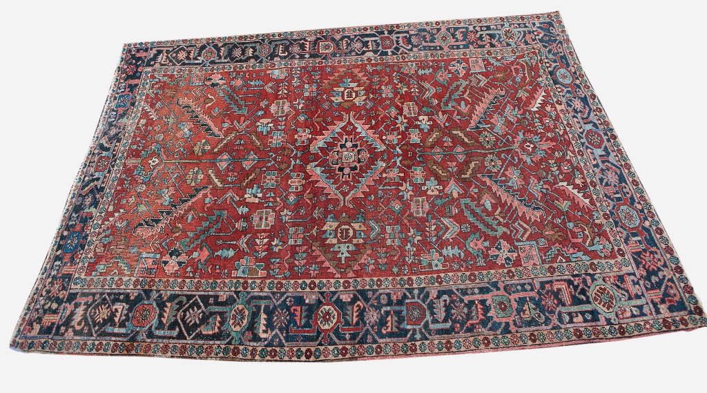 A HERIZ RUST GROUND CARPET with all over polychrome stylised decoration within a deep blue border,