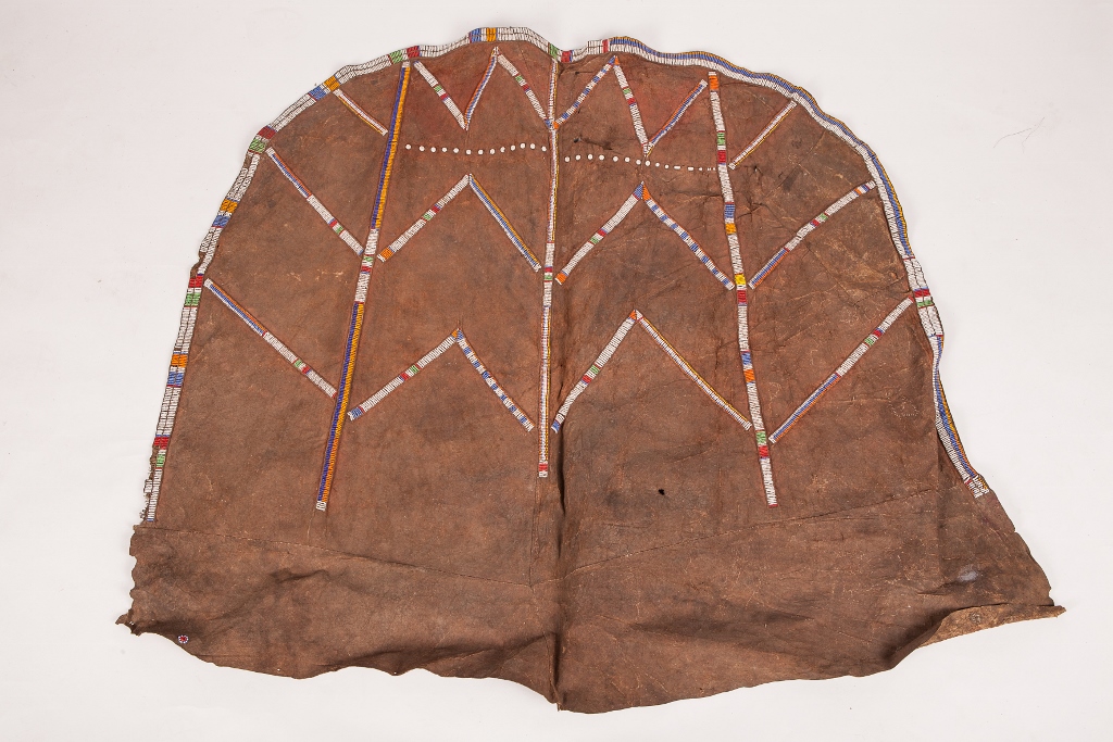 AN OLD AFRICAN ANIMAL HIDE AND COLOURED BEAD CLOAK with simple geometric decoration, approximately