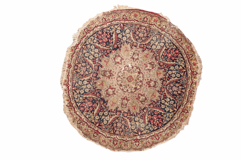 A KIRMAN CIRCULAR MAT with central medallion and foliate decoration on a blue ground,