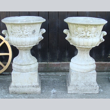 A pair of reconstituted stone garden urns, on pedestal bases, 95cm tall