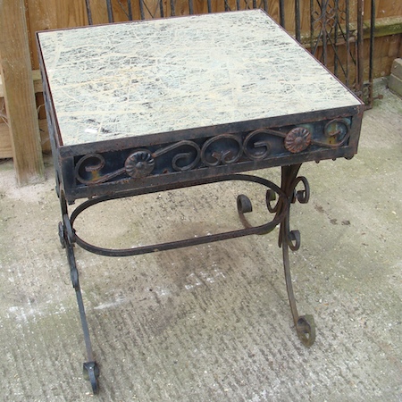 A marble top garden table, on a black wrought iron base, 76cm tall