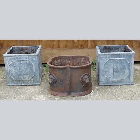 A painted cast iron planter, together with a pair of square fibreglass planters, 31cm tall