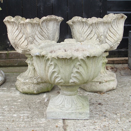 A collection of three reconstituted stone campana shaped urns, 60cm tall