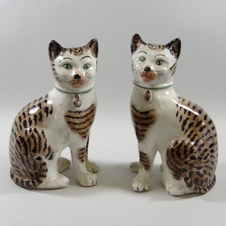 A rare pair of 19th century Staffordshire pottery models of seated cats, each 23cm tall