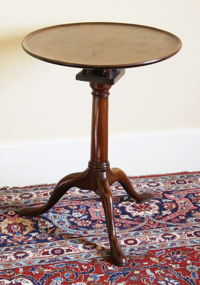 A George III mahogany tripod table the dished circular top with birdcage action on a gun barrel