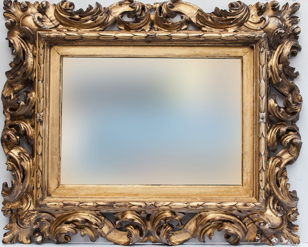 An 18th century Florentine style pierced and carved giltwood picture frame converted to a mirror,