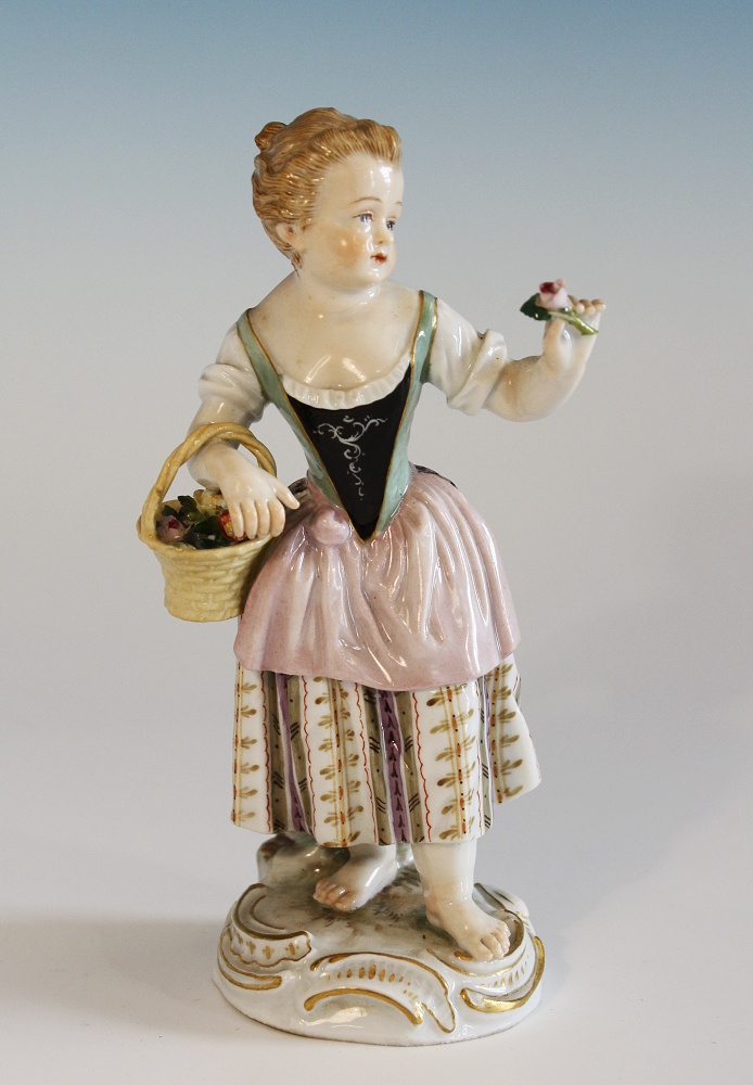 A Meissen figure portraying a female flower seller late 19th century, a basket hooked over her