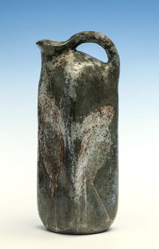 A Martin Brothers jug c.1898, of tall square form, green/grey mottled glaze with engraved grotesque