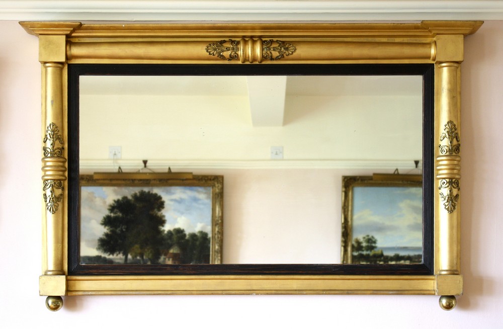 A William IV giltwood overmantel mirror the frame formed from rounded columns applied with gilt
