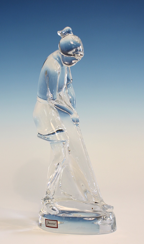 A Baccarat crystal female golfer figurine posed lining up a shot, the base with etched factory