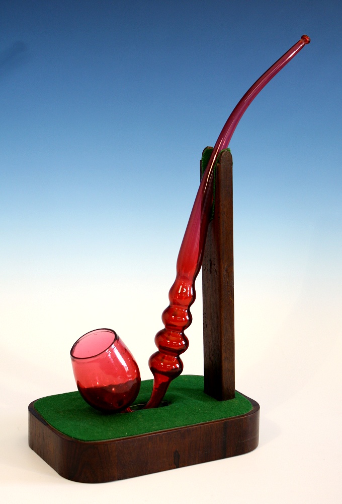 A Victorian cranberry glass pipe deep bowl on upturned neck into four knops and elongated tapering