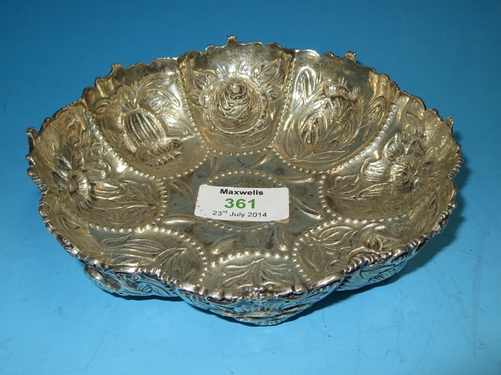 A circular lobed dish with embossed floral decoration, London 1185, 5 oz.