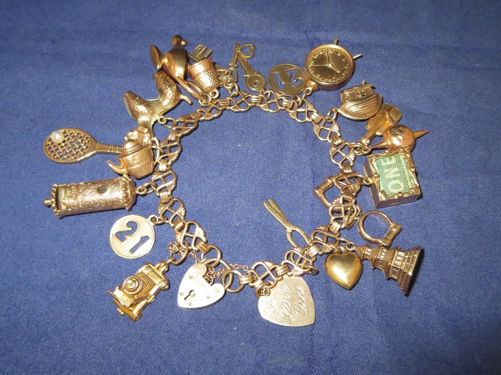 A 9 carat hallmarked gold charm bracelet with approximately 24 charms, some hallmarked 9 carat