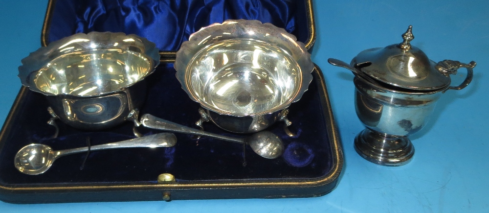 A cased pair of silver salts and spoons, Sheffield 1896 (1 leg a.f.); a pedestal mustard pot with