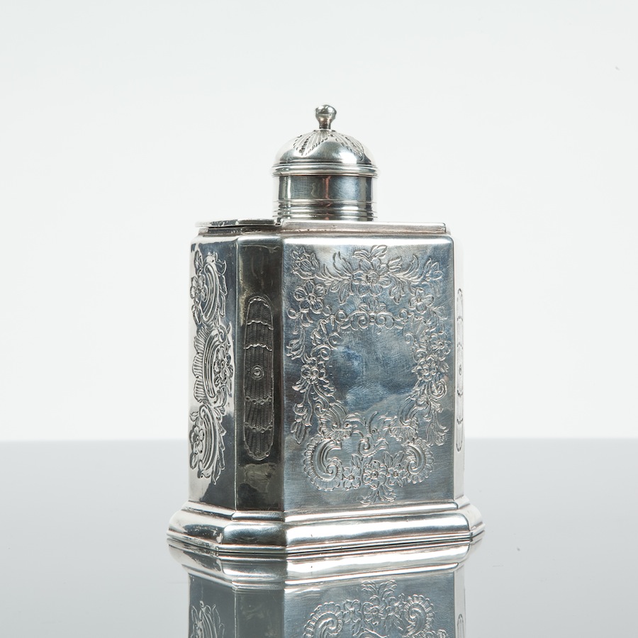 GEORGE I SILVER TEA CADDY of canted rectangular form, with sliding domed cover, the front chased