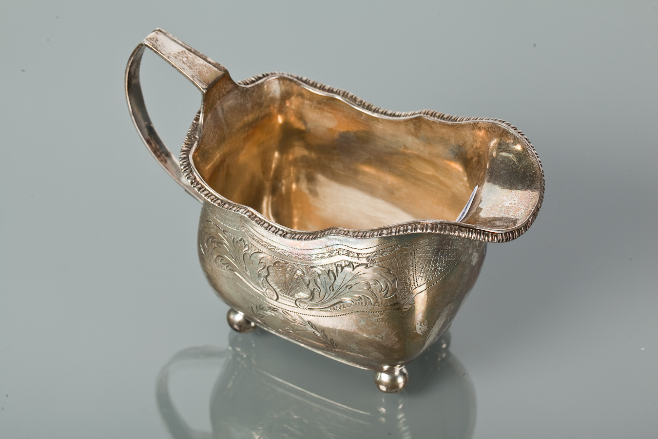 IRISH SILVER CREAM JUG of rectangular form with gadrooned rim, shell and foliate engraved body and