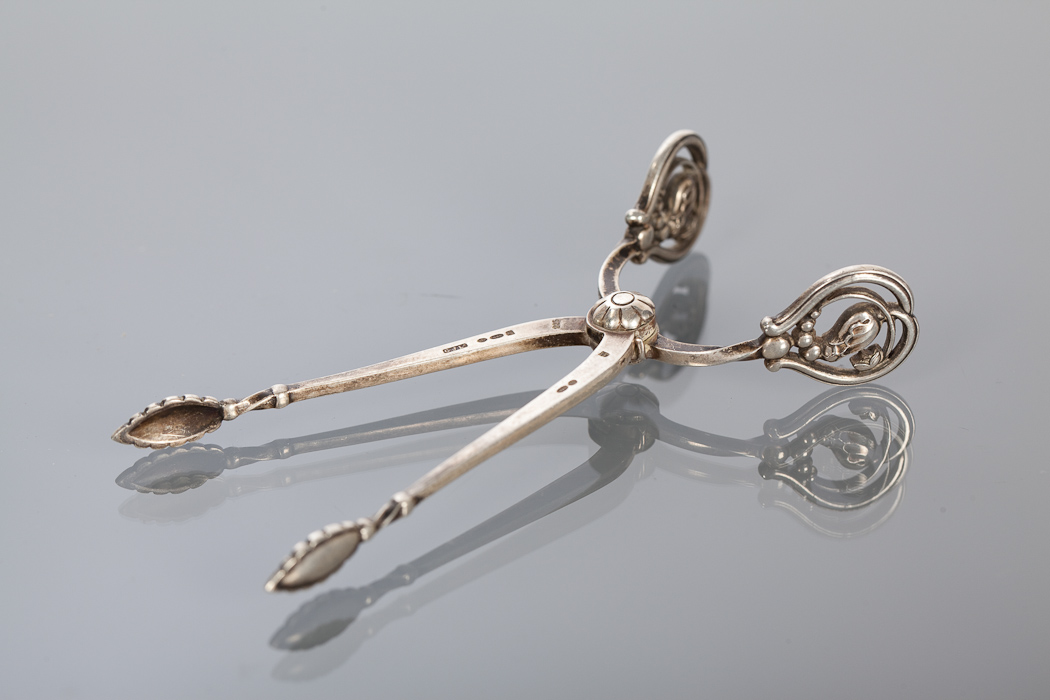 PAIR OF GEORG JENSEN BLOSSOM PATTERN SUGAR TONGS with sprung arms, leaf bowls and pierced blossom