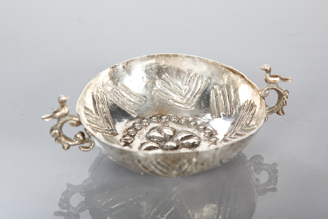 WHITE METAL TAZ DU VIN the handles mounted by birds, the bowl embossed with a central flower, 14cm