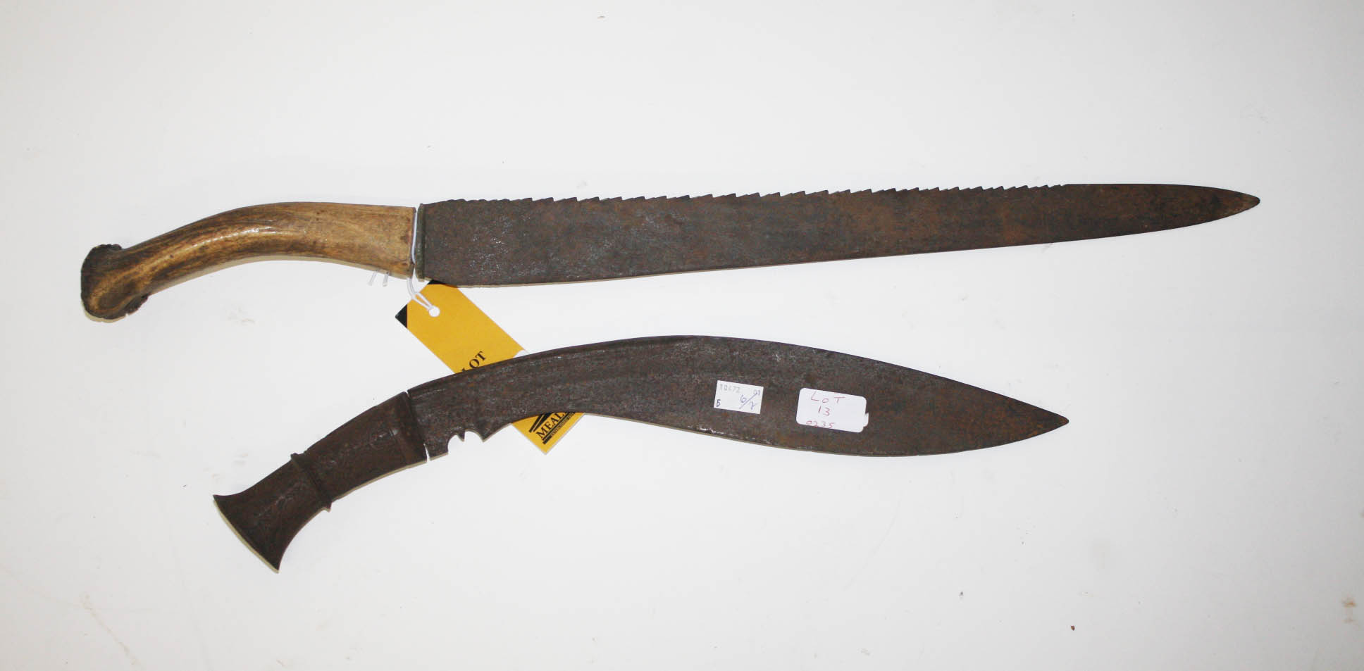 A SAW BACK BUSH KNIFE,
with double edge blade, and stag horn handle, the blade 19in (48cm), one side