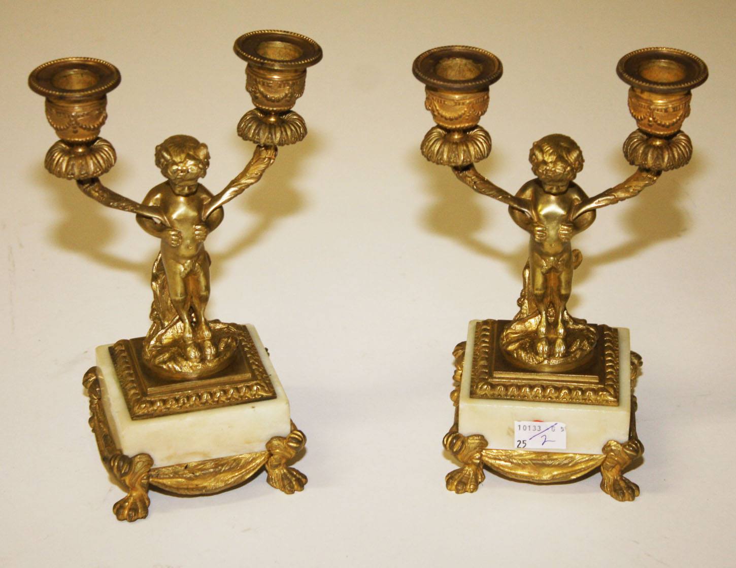 AN ATTRACTIVE PAIR OF FRENCH GILT BRASS CANDELABRA,
each modelled with  Pan, supporting two urn