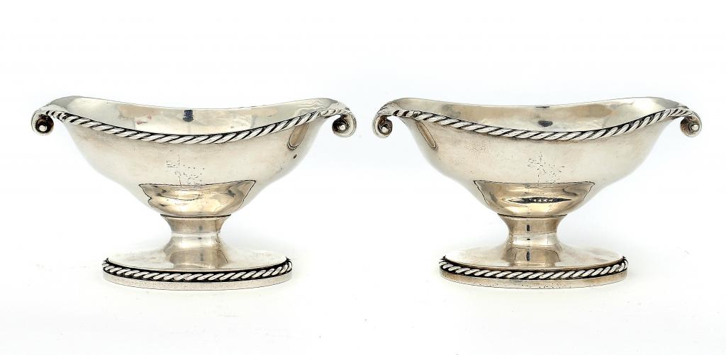 A PAIR OF GEORGE III SALT CELLARS  with lipped oval bowl and cable rim, crested, by Robert Hennell,