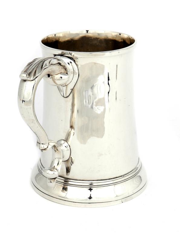 A GEORGE III QUART MUG   slightly waisted with leaf capped double scroll handle, on domed foot,15.