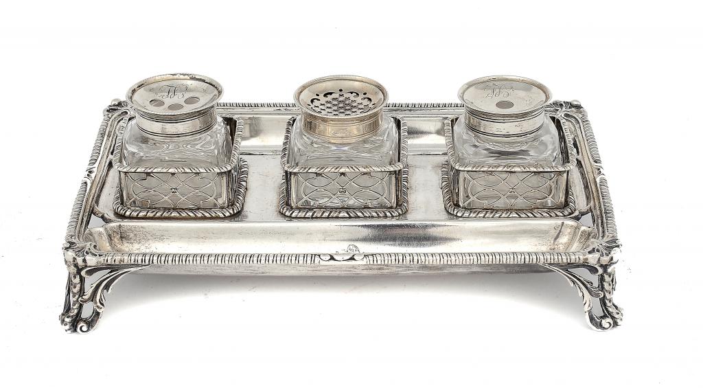 A GEORGE III INKSTAND with pierced galleries and gadrooned rims, retaining the three silver mounted