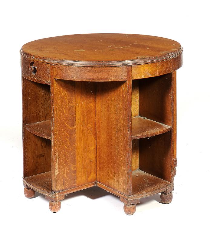 AN ARTS & CRAFTS OAK BOOK TABLE  the round top on cruciform base with two drawers and open shelves