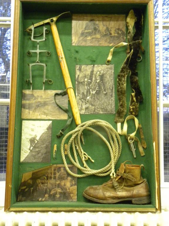 MOUNTAINEERING. A DISPLAY OF VINTAGE MOUNTAINEERING EQUIPMENT AND PRINTS IN GREEN BAIZE LINED BOX