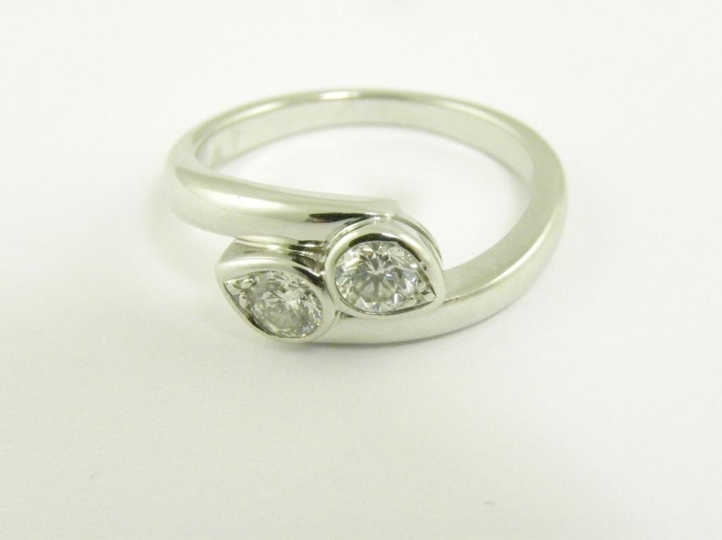 A DIAMOND CROSSOVER RING WITH PEAR SHAPED DIAMONDS IN 19CT WHITE GOLD, 5.3G