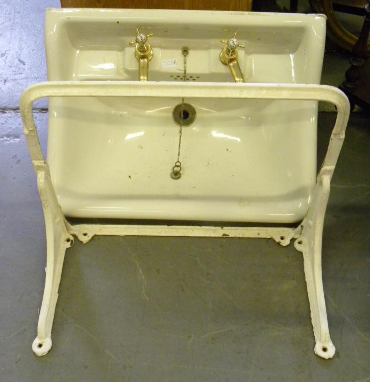 AN EDWARDIAN SINK WITH BRASS TAPS AND BRACKET FOR FIXING