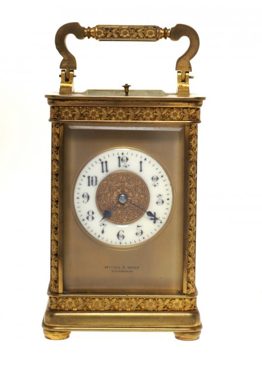 A FRENCH GILT BRASS CARRIAGE CLOCK with primrose enamel chapter ring and mask signed WILSON &