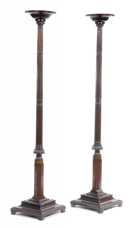 A PAIR OF MAHOGANY TORCHÈRES the dished top on leaf carved and fluted tapering shaft,  moulded