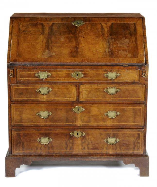 A GEORGE II WALNUT AND FEATHERBANDED BUREAU the flap veneered in four sections and revealing a