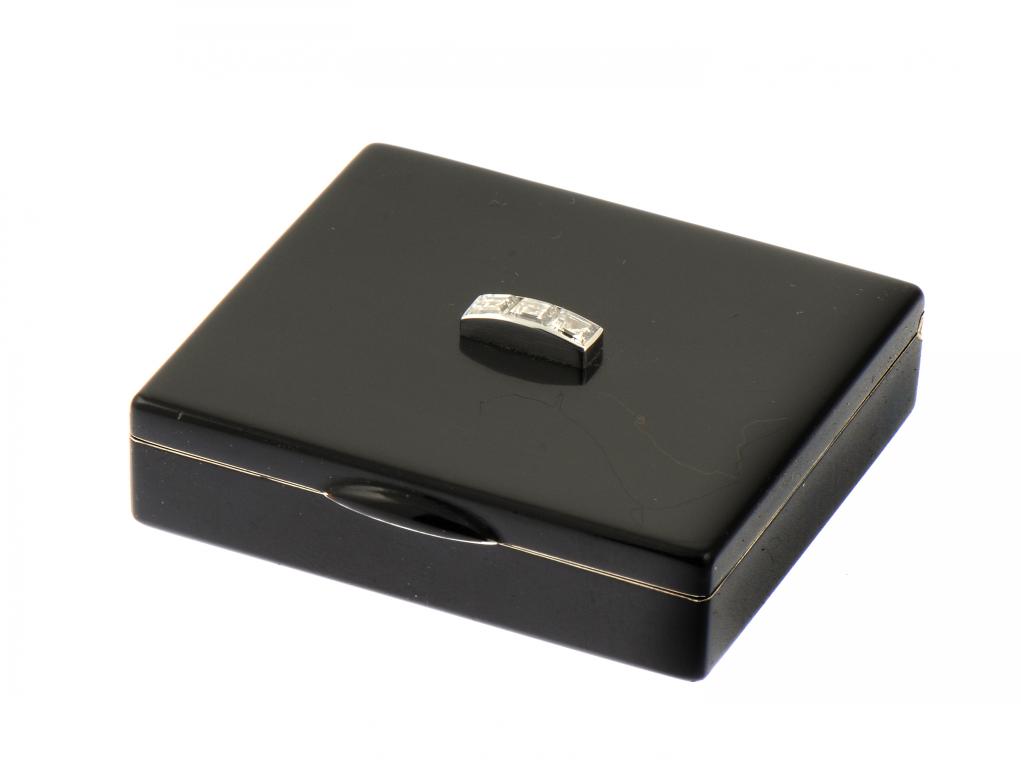 AN ART DECO DIAMOND SET GOLD AND BLACK ENAMEL VANITY BOX BY CARTIER with integral hinge, a mirror to