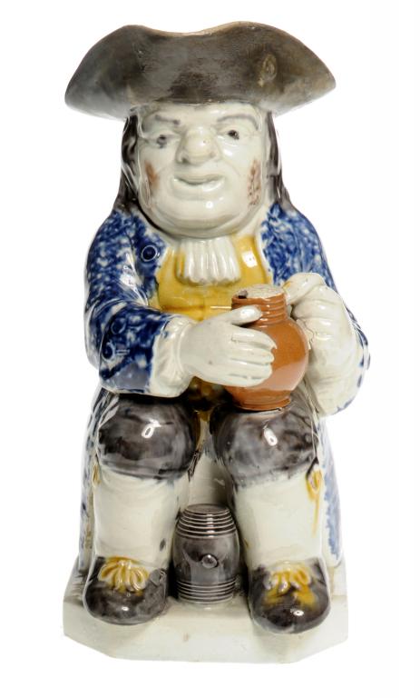 A PRATTWARE TOBY JUG  the seated toper holding a jug of ale on his left knee, a small manganese