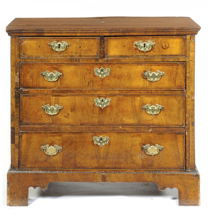 A GEORGE II WALNUT CHEST OF DRAWERS  the quarter veneered and crossbanded, moulded top above two