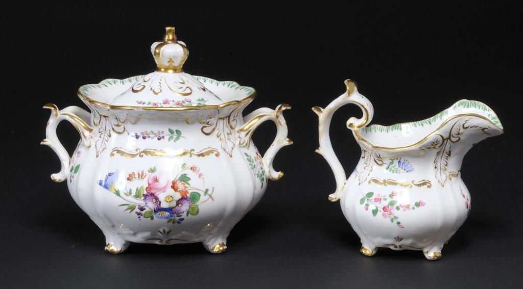 A ROCKINGHAM CREAM JUG AND SUCRIER AND COVER  of three spur handle shape, painted in bright