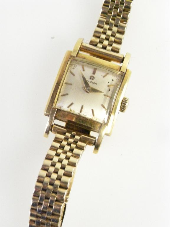 AN OMEGA 18CT GOLD LADIES WRISTWATCH OF SQUARE DESIGN ON GOLD TAPERED MESH BRACELET, THE CLASP