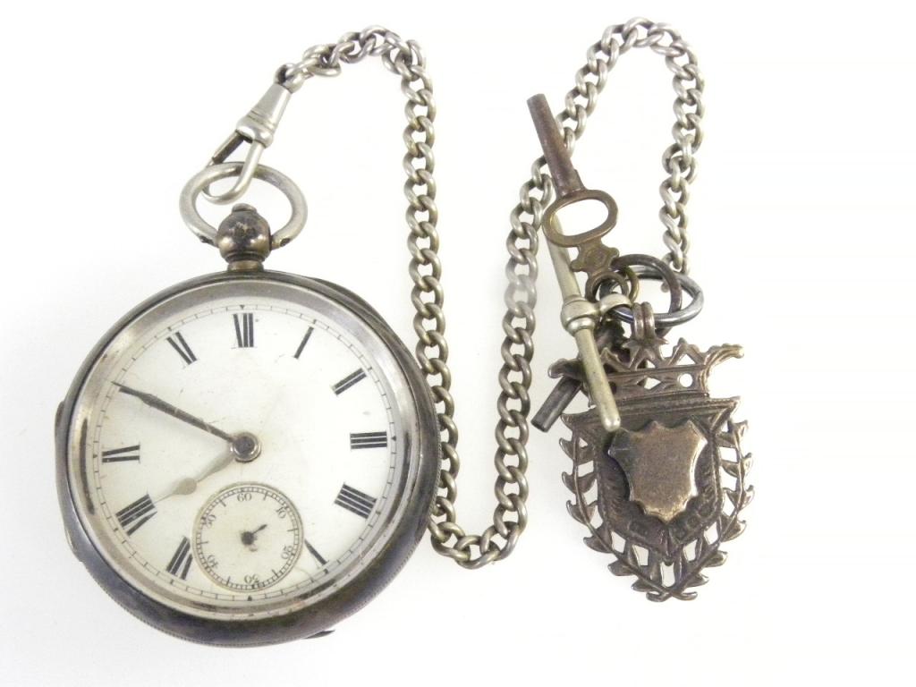 A SILVER LEVER WATCH WITH ENAMEL DIAL, CHESTER 1893 WITH AN ALBERT AND PIERCED SILVER FOB SHIELD