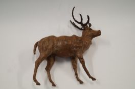 An interesting 20th century leather covered figure of a deer with glass insert eyes