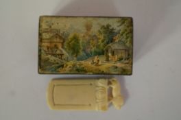 A small 19th century papier mache snuff box decorated with a river, along with an ivory paper clip