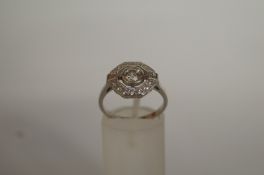 An Art Deco style diamond cluster ring, the central stone of approximately 0.40cts, enclosed by