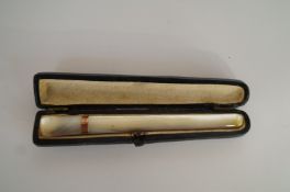 A mother of pearl cigarette holder with a 9ct gold collar, cased