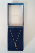 A gold letter J pendant, on a chain; approximately 0.4 grams gross