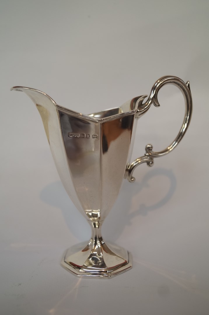 A silver cream jug, by E.F. Branham Ltd. Birmingham 1897, of fluted pedestal helmet shape, with