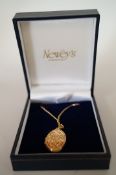 A 9ct gold oval locket, on a 9ct gold filed curb link chain, locket 2.7cm long; chain 45cm long;